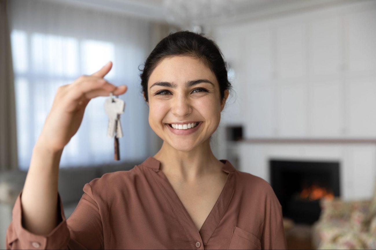 Woman holding keys to her new house ©fizkes